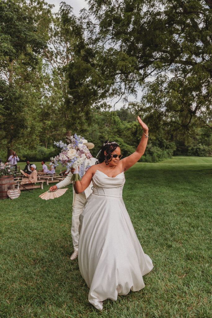 Bride holding purple and blue floral bouquet at Kennedy Estate