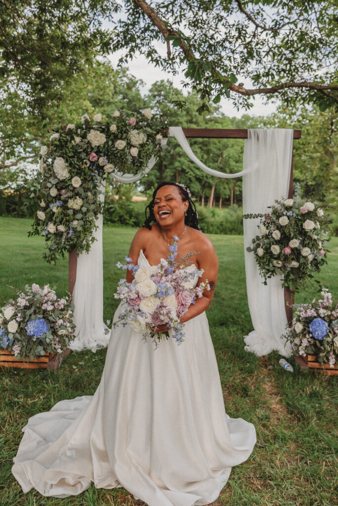 Bride holding purple and blue floral bouquet at Kennedy Estate