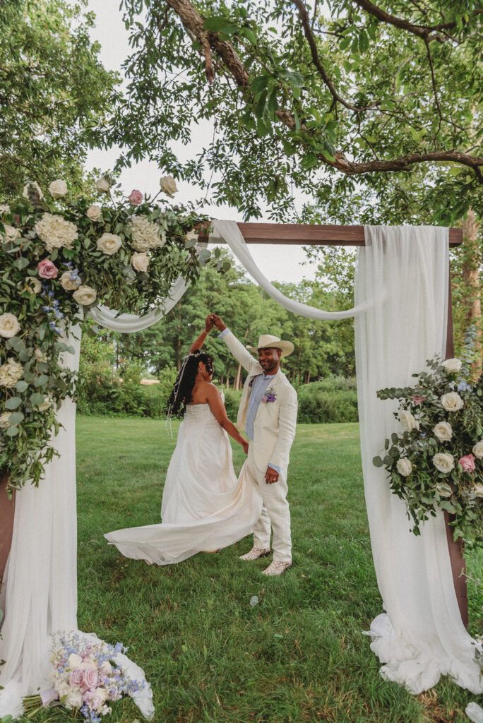 Romantic wedding portrait of newlyweds surrounded by greenery