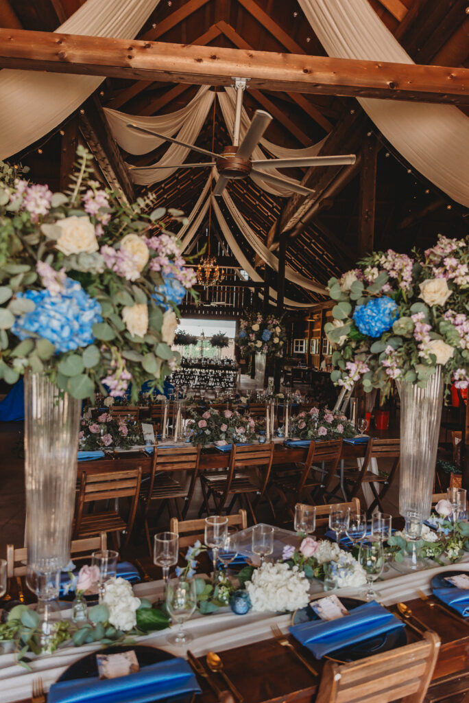 Purple and blue wedding reception tablescape with floral centerpiece