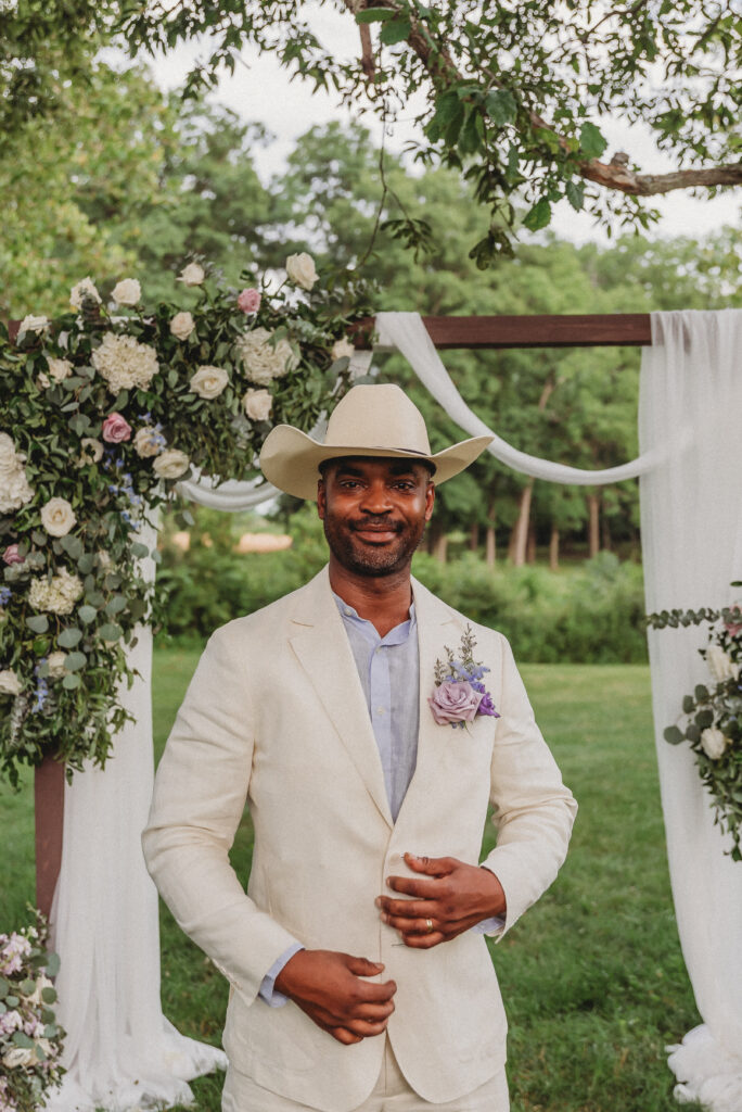 Groom wearing cowboy hat during Western-inspired wedding portraits
