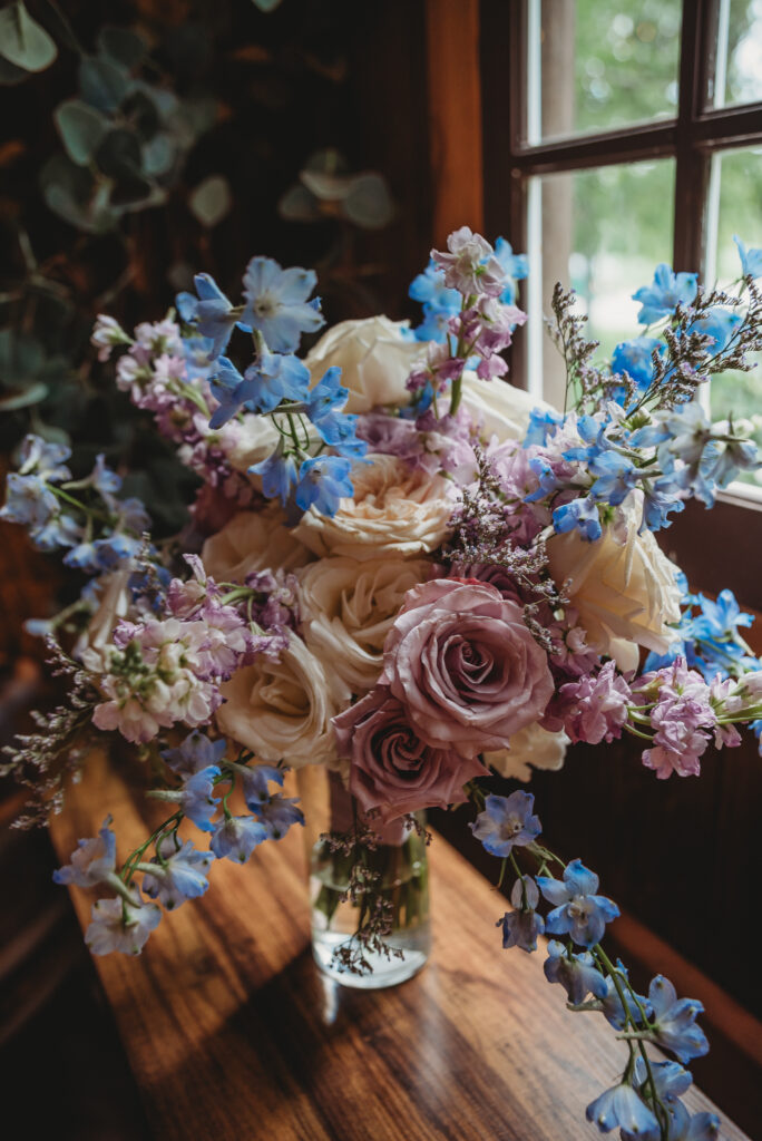 Cleos purple and blue bridal bouquet with ivory flowers and greenery
